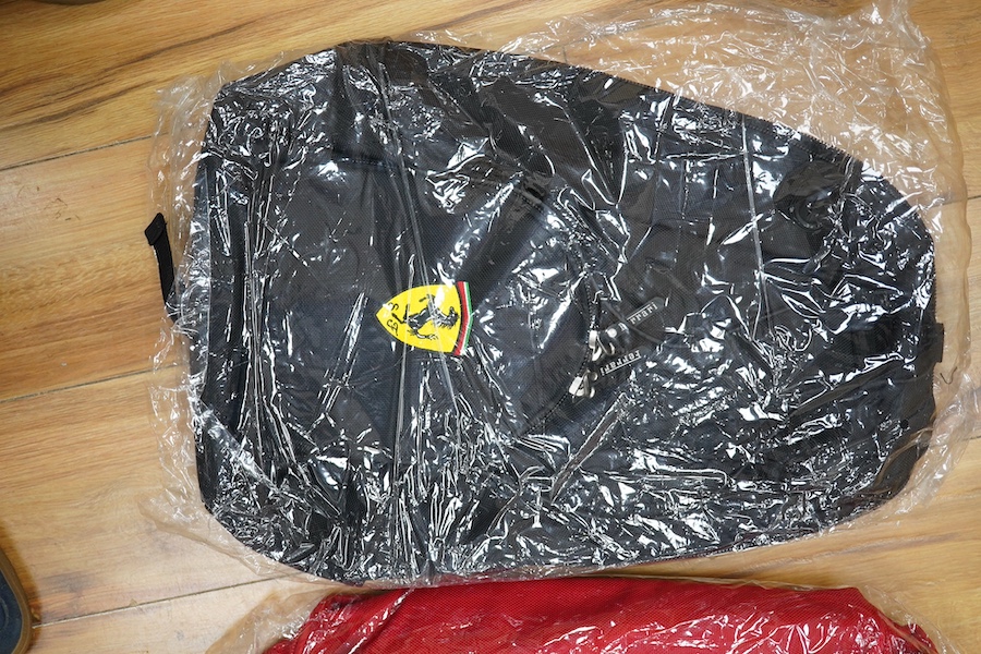 Two official Ferrari branded bags; a backpack and a duffle bag, both new with tags, both contained within an original Ferrari plastic bag dated 2002. Condition - good.